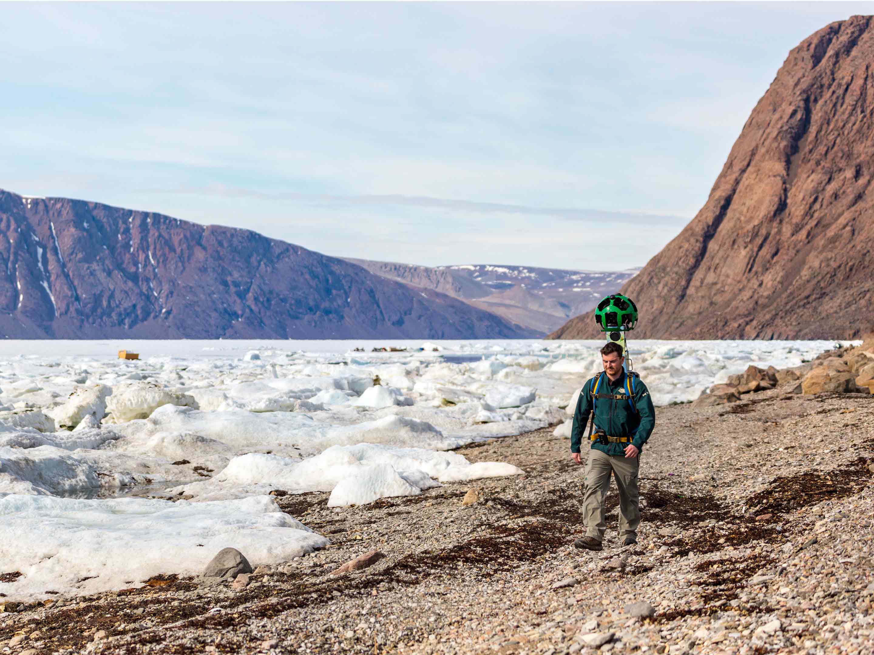 quttinirpaaq national park trekker walking next to a glacier