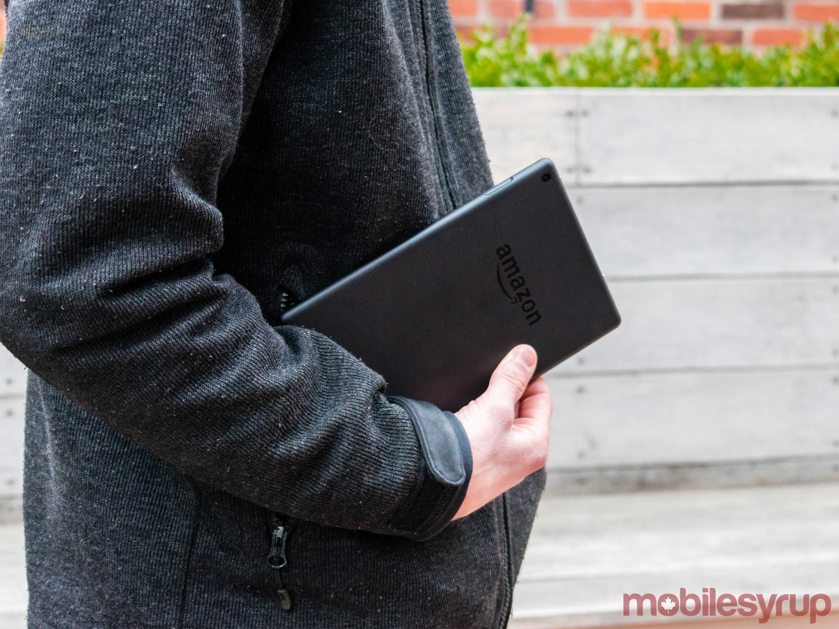 Man holding the Amazon tablet while standing. 