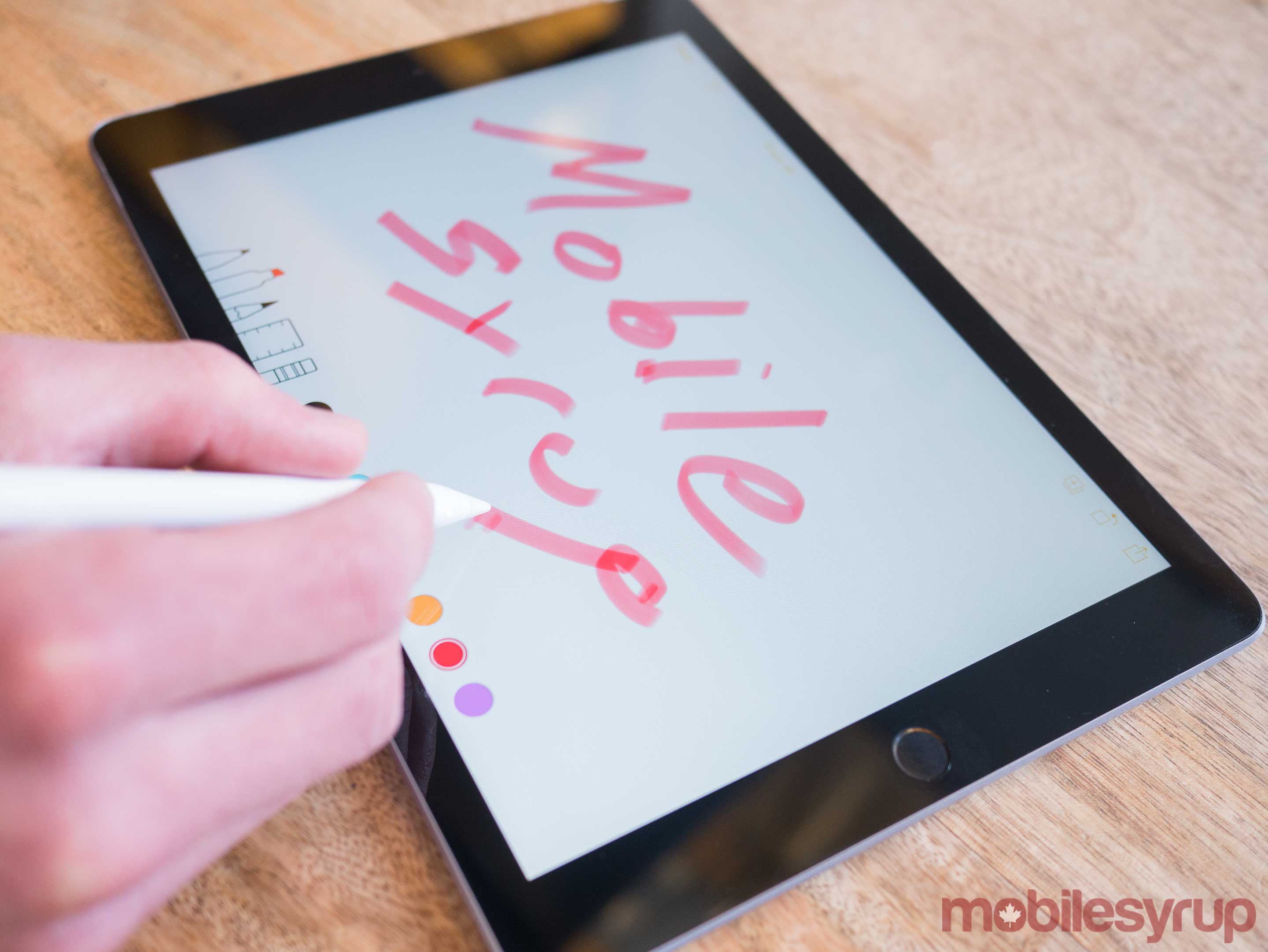 9.7-inch iPad writing MobileSyrup with Apple Pencil
