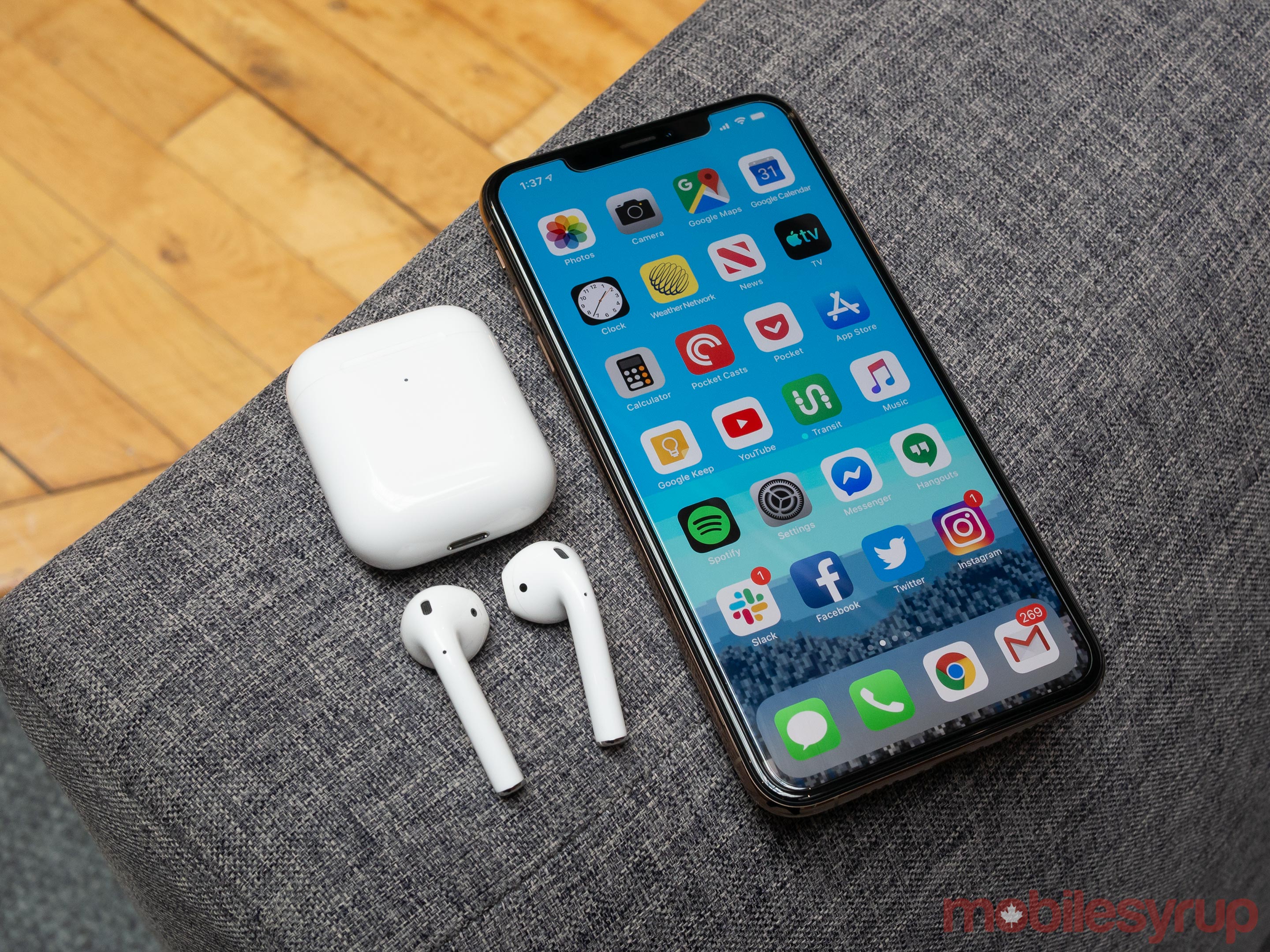 AirPods (2019) beside an iPhone XS Max